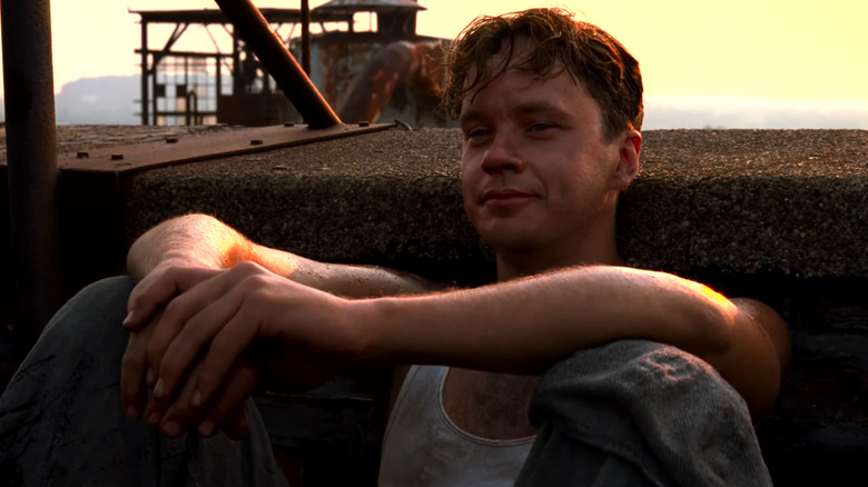 Andy sits with a smile on his face in The Shawshank Redemption