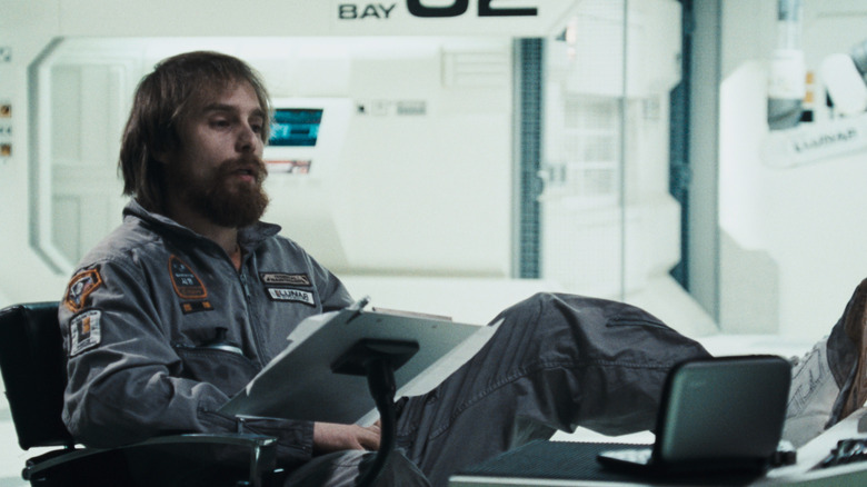 Sam Rockwell as Sam Bell in Moon with shaggy hair and a beard