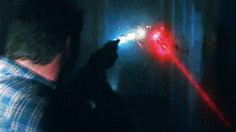 Man points gun at laser