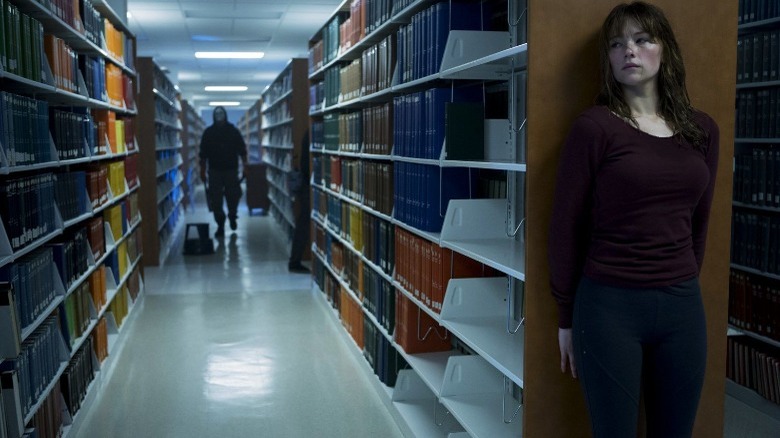 Haley Bennett hiding by bookshelf