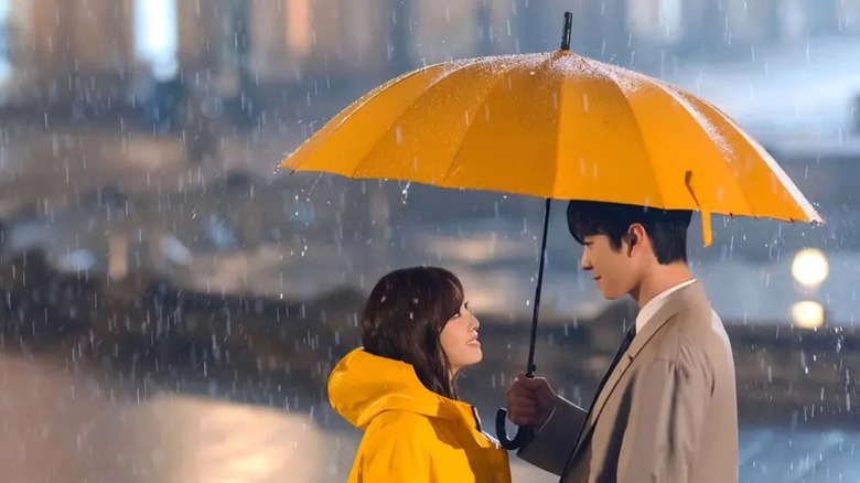 Kang Tae-moo (Ahn Hyo-seop) holds an umbrella over Shin Ha-ri (Kim Se-jeong) in Business Proposal