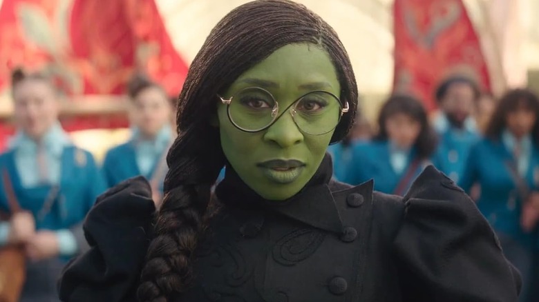 Cynthia Erivo's Elphaba standing in front of Shiz University in Wicked