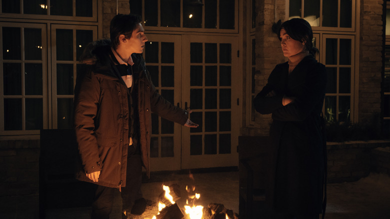 Gunnar Albright and Tricia Albright standing near fire