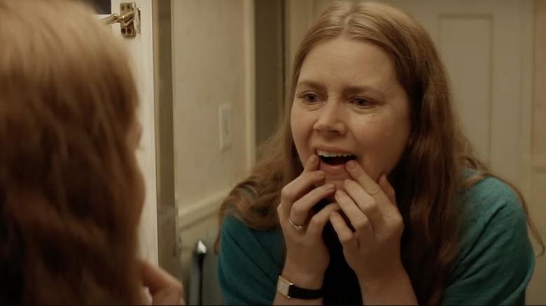 Amy Adams as Mother looking at her canine teeth in Nightbitch