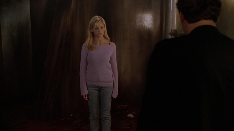 Buffy's Buffy Summers standing in front of Angel in purple sweater