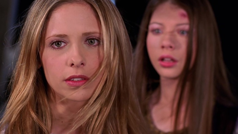 Buffy's Buffy Summers turning with tears in her eyes and Dawn behind her