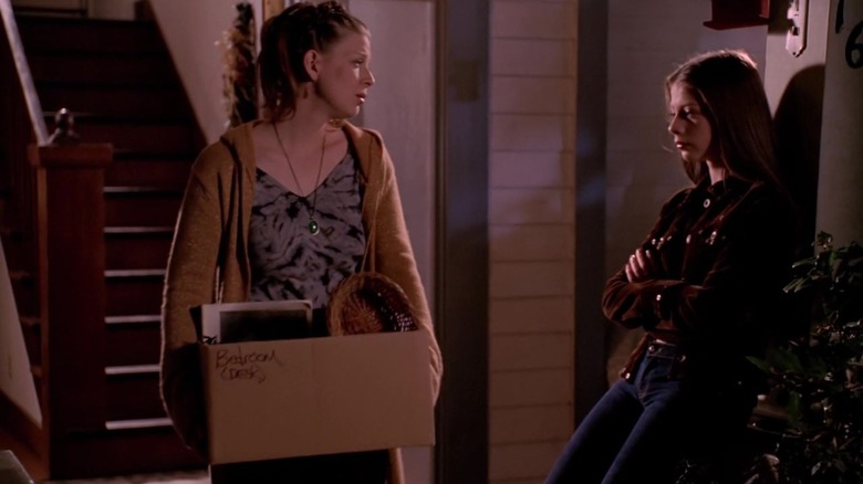 Buffy's Tara walking out of the house with box while Dawn stands by 