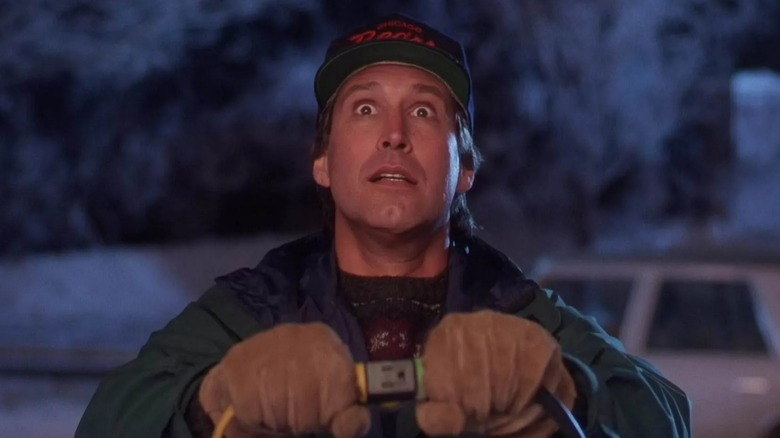 Chevy Chase's Clark looks eager as he plugs in a Christmas light cord in National Lampoon's Christmas Vacation