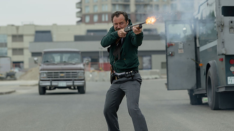 Jude Law as FBI agent Terry Husk shooting at bank robbers in The Order