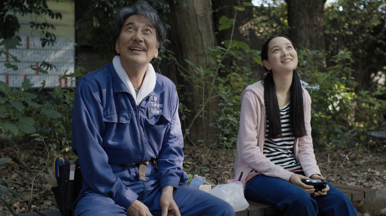 Kôji Yakusho as Hirayama and Arisa Nakano as Niko enjoying nature at a park in Perfect Days