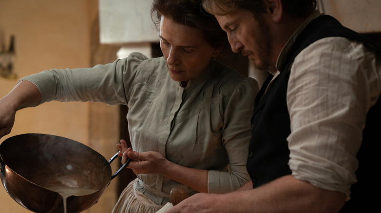 Juliette Binoche as Eugénie and Benoît Magimel as Dodin cooking together in The Taste of Things