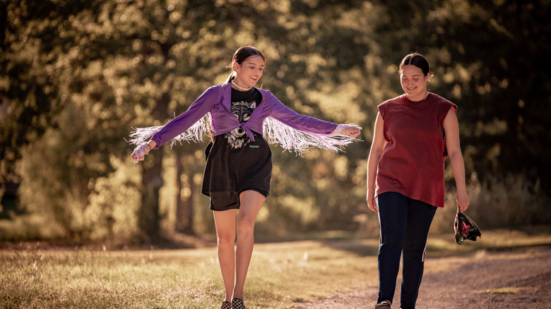 Isabel Deroy-Olson as Roki and Lily Gladstone as Jax walking down a street in Fancy Dance