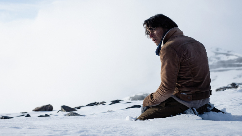 Enzo Vogrincic as Numa kneeling despondently in the snow in Society of the Snow