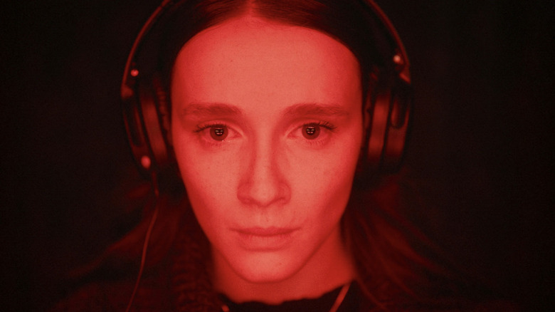 Juliette Gariépy stars as Kelly-Anne wearing headphones and washed in red light in Red Rooms