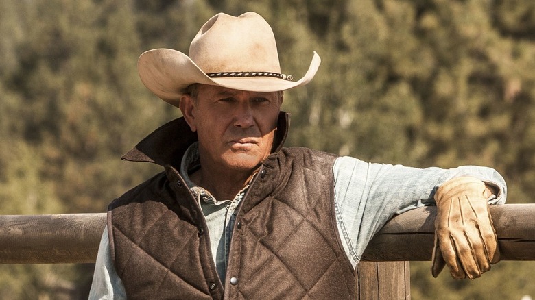 John Dutton leaning on a fence post in Yellowstone