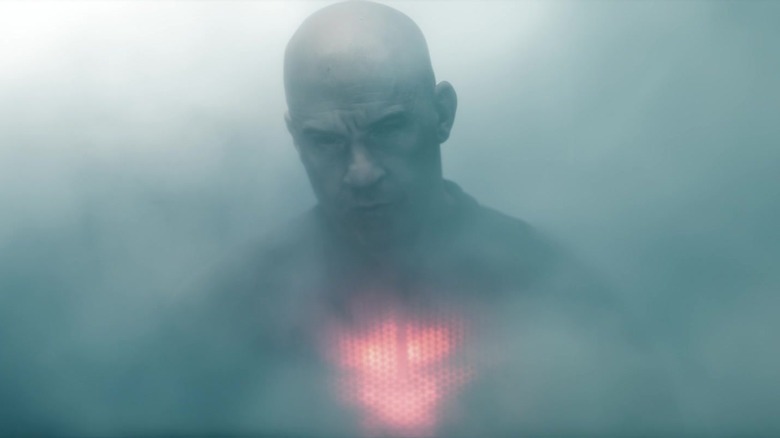 Vin Diesel as Bloodshot walks through smoke with his chest glowing red in Bloodshot