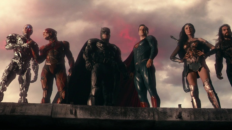 Ray Fisher as Cyborg, Ezra Miller as the Flash, Ben Affleck as Batman, Henry Cavill as Superman, Gal Gadot as Wonder Woman, and Jason Mamoa as Aquaman all standing on a metal ledge with red skies above them in Justice League 2017