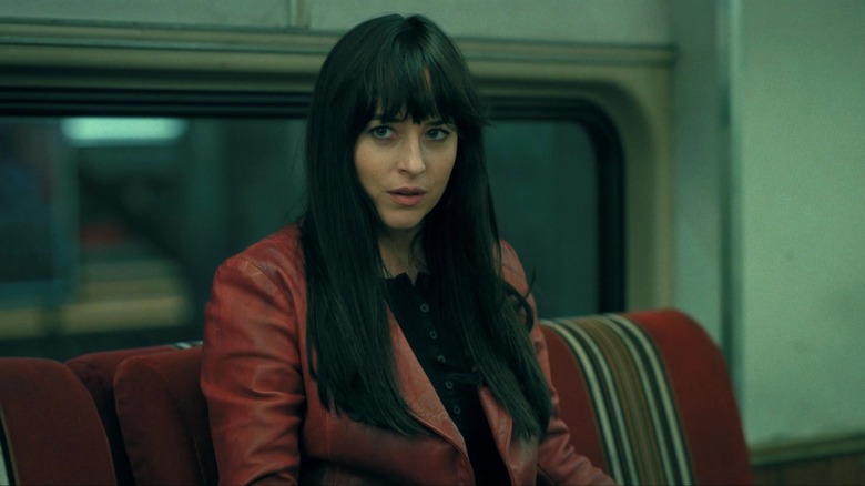 Dakota Johnson as Cassandra Webb looking concerned on the subway in Madame Web