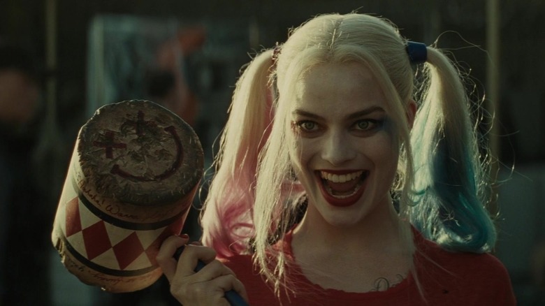 Margot Robbie as Harley Quinn holding a mallet and in grinning in Suicide Squad 2016