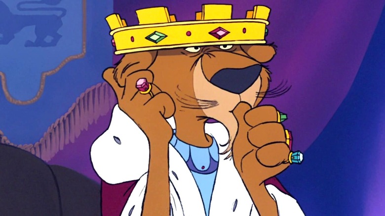 Prince John wears his gold crown and purple and white robe while holding his ear and sucking his thumb in Robin Hood