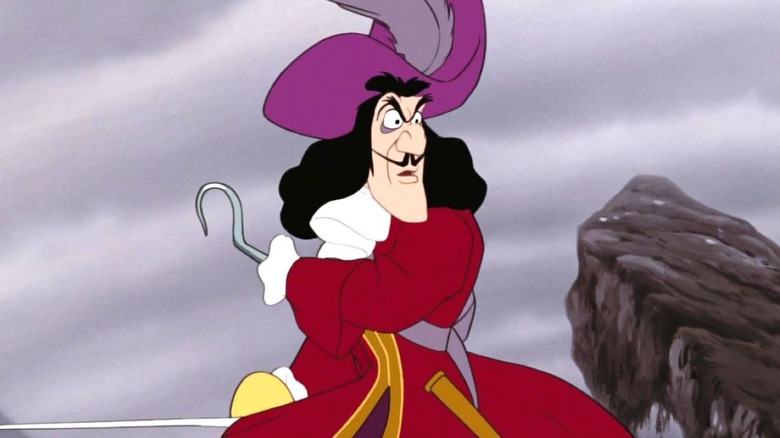 Captain Hook stands next to a rock formation while looking toward the right and holding his sword behind him in Peter Pan