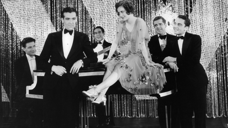 Joan Crawford sitting on a piano for The Hollywood Revue