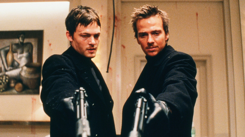 Murphy MacManus (Norman Reedus) and Conner MacManus (Sean Patrick Flannery) pointing guns in The Boondock Saints