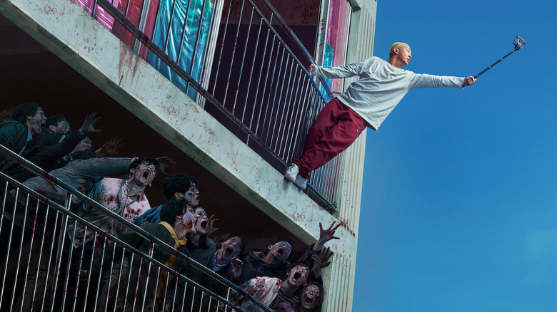 A character hangs off his balcony zombies in apartment below