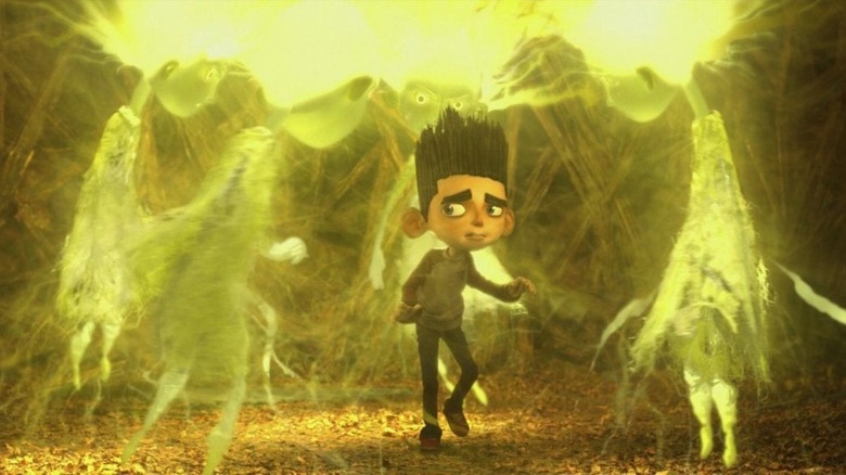 A young animated boy is surrounded by ghosts