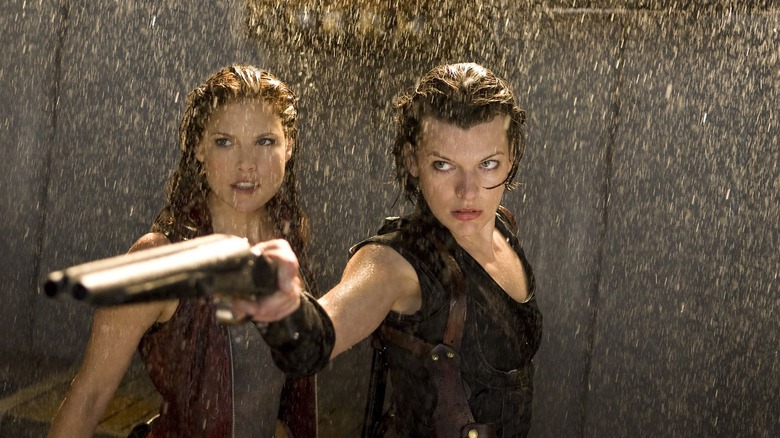 Ali Larter and Milla Jovovich, extending a sawed-off shotgun, face an unknown threat.