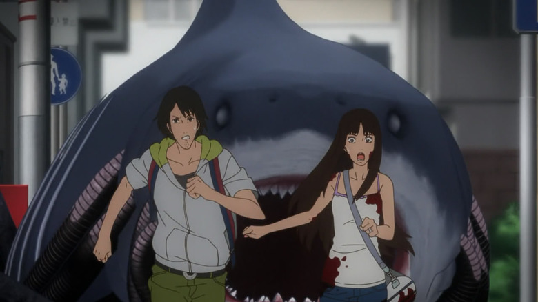 A man and a woman run from a massive shark