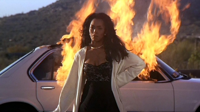 Bernadine Harris standing in front of burning car