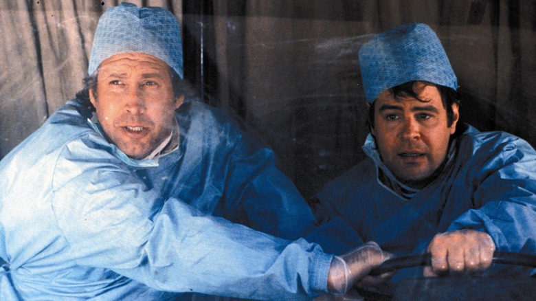 Chase and Aykroyd in scrubs driving truck