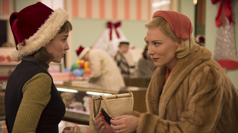 Rooney Mara as Therese and Cate Blanchett as Carol talk at a counter in Carol (2015)