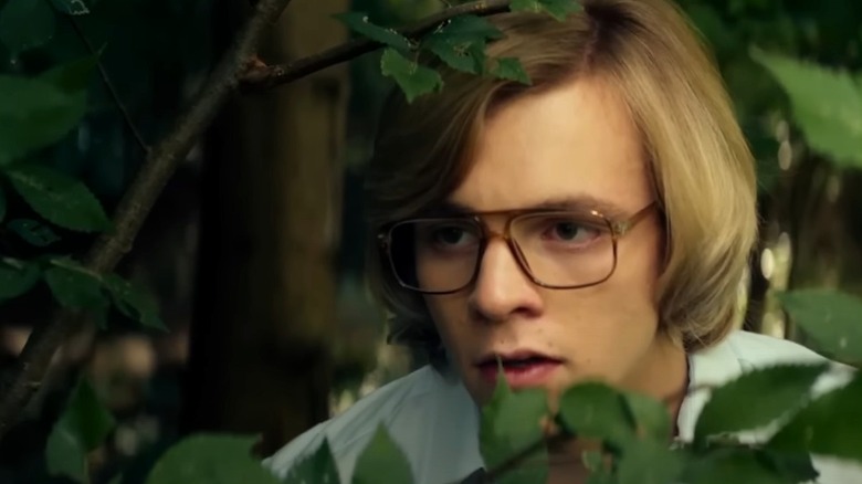 Ross Lynch as Jeffrey Dahmer peering through bush in My Friend Dahmer