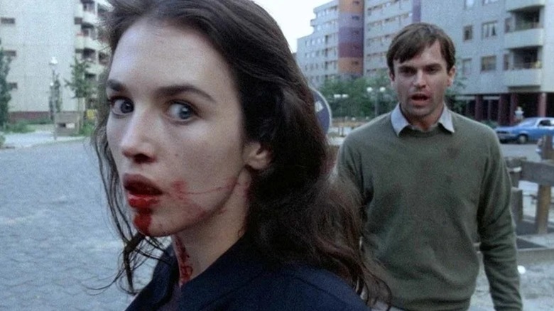 Anna/Helen with a bloody mouth while Mark stands behind her in Possession