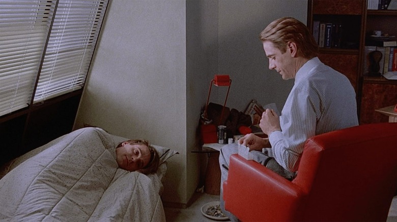 Elliot and Beverly, one seated next to the other lying in a bed, in Dead Ringers