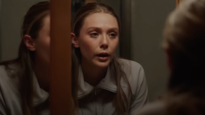 Elizabeth Olsen as Jane Banner looks in a mirror in Wind River