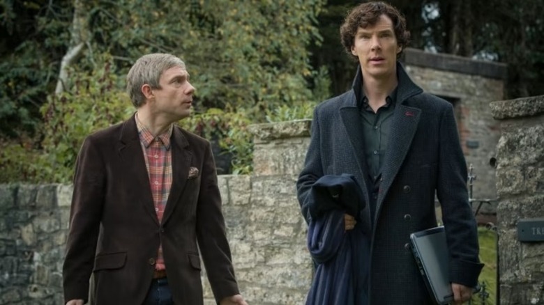 Sherlock John Watson walks with Sherlock Holmes in a forested cemetary