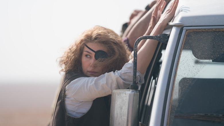 Rosamund Pike leans against car