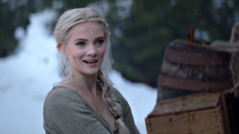 Ciri standing in the snow and smiling