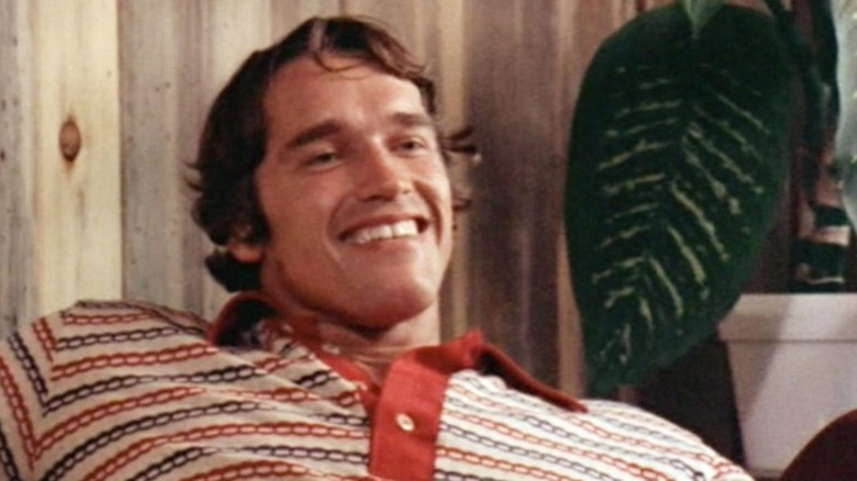 Arnold Schwarzenegger smiling in a striped shirt