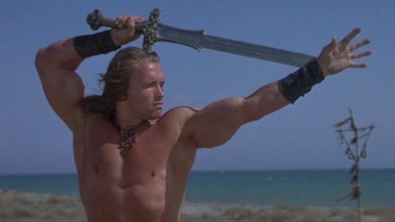 Conan wielding a sword on the beach