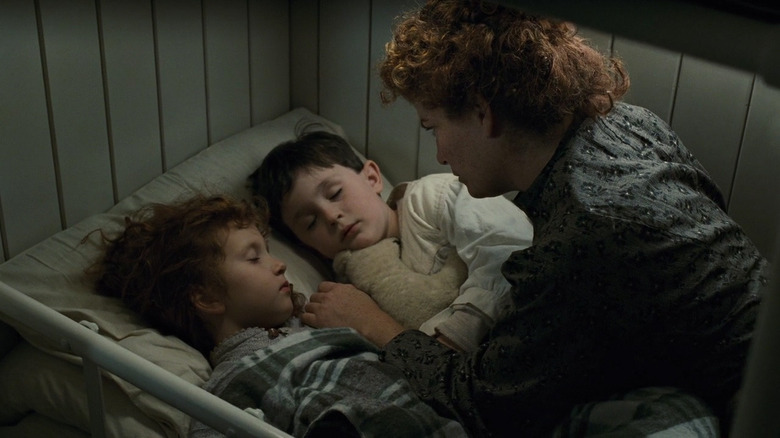 Woman talking to her children in bed in Titanic