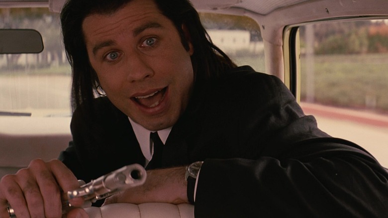 John Travolta speaking and holding gun