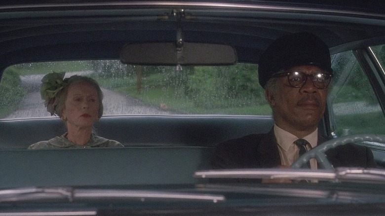 Hoke Colburn driving a car while Daisy Werthan sits in the backseat in Driving Miss Daisy