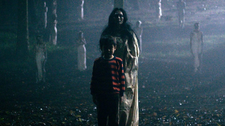 Boy and demon standing in a field