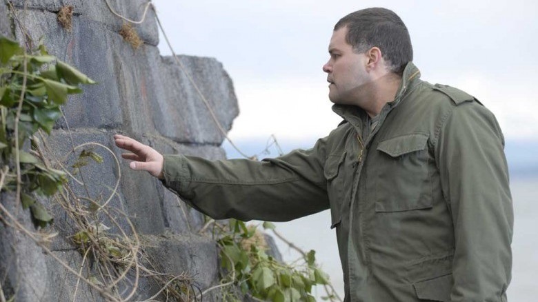 Battlestar Galactica's Chief despondently studies a wall.