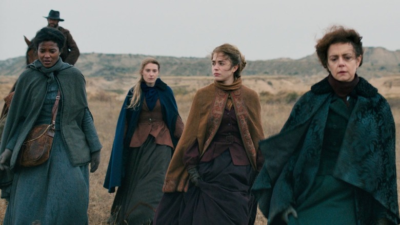 Women walk through windy landscape