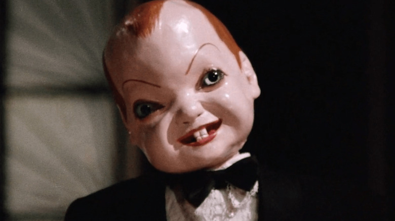 A creepy doll with scary teeth and thin eyebrows in Deep Red